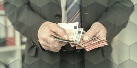 Businessman counting his money at office, geometric patternの写真素材