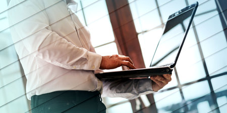 Standing senior businessman working on laptop, geometric patternの写真素材