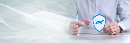 Man holding a virus and shield with airplane; concept of prevention and virus protection when...