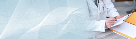 Doctor taking notes on clipboard in medical office; panoramic bannerの写真素材