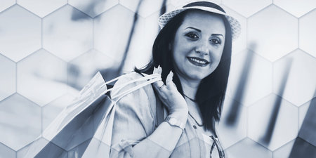 Pretty young woman walking with shopping bags in hand, geometric patternの写真素材