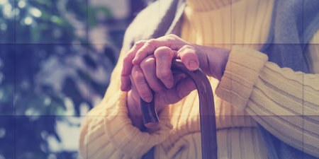 old woman sitting with her hands on a cane, geometric patternの写真素材