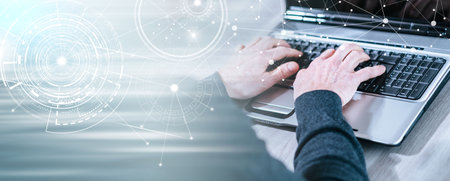 Male hands typing on laptop keyboard; panoramic banner