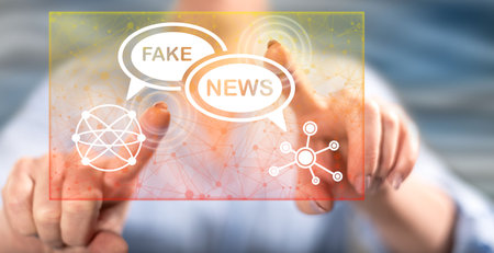 Woman touching a fake news concept on a touch screen with her fingersの写真素材
