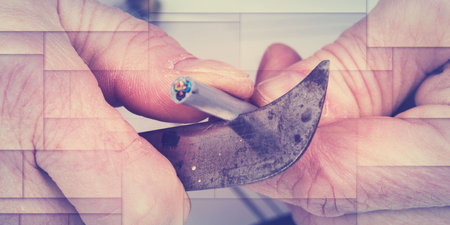 Hand cutting the insulation of a power cable, geometric patternの写真素材