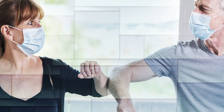 Mature man and woman having elbow greeting during covid outbreak, geometric patternの写真素材