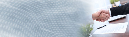 Businesswoman and businessman shaking hands (lorem ipsum text used); panoramic bannerの写真素材