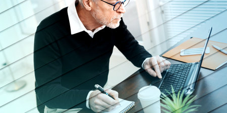 Senior businessman taking notes on notebook, geometric patternの写真素材