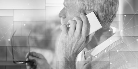 Senior businessman talking on mobile phone and looking through the window, light effect, overlayed with network, geometric patternの写真素材