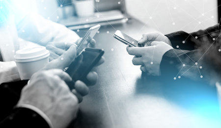 group of people using and looking at mobile phone together; light-effectの写真素材