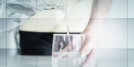 Woman pouring water from a jug into a glass, geometric patternの写真素材