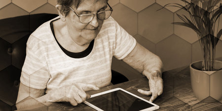 Elderly woman using a tablet, geometric patternの写真素材