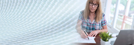 Businesswoman analyzing marketing graphs at office; panoramic bannerの写真素材