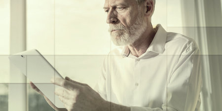 Senior businessman using a digital tablet in office, hard light, geometric patternの写真素材