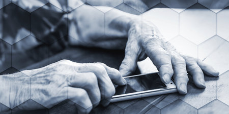 Elderly person using smartphone at home, geometric patternの写真素材