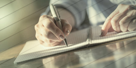 Woman with pen writing on notebook, geometric patternの写真素材