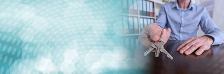 Estate agent offering house keys on a wooden table; panoramic bannerの写真素材