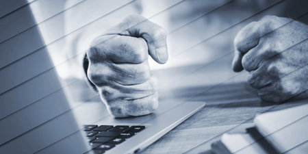 Enraged businessman banging his clenched fists on the desk, geometric patternの写真素材