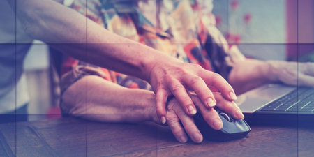 Old woman learning to use a mouse of a computer, geometric patternの写真素材