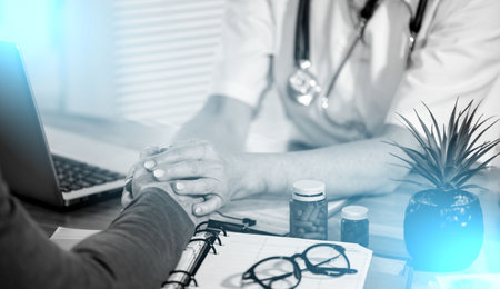 Female doctor holding patient hand for encouragement; light effectの写真素材