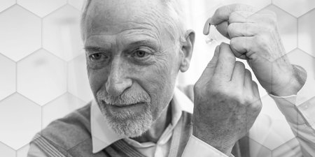 Senior man putting hearing aids, geometric patternの写真素材