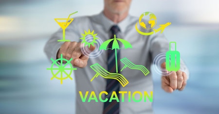 Man touching a vacation concept on a touch screen with his fingersの写真素材