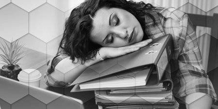 Exhausted businesswoman with a stack of folders on her desk, geometric patternの写真素材