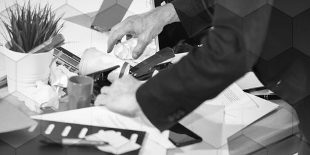 Disorganized businessman looking for documents on his messy desk, geometric patternの写真素材