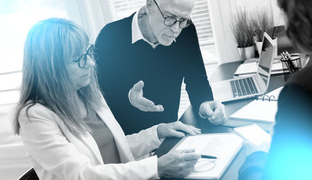 Group of three coworkers during business meeting at office; light effect