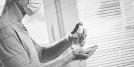 Man using hand sanitizer alcohol gel; prevention of viruses and bacteria infection, geometric patternの写真素材