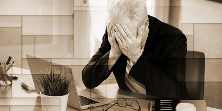 Overworked and exhausted senior businessman sitting at workplace, geometric pattern