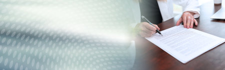 Businesswoman reading and checking document in office (lorem ipsum text used); panoramic bannerの写真素材