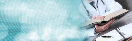 Doctor reading a textbook in medical office; panoramic banner