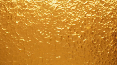 A shimmering golden texture highlighted by a dappled lighting patternの素材