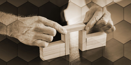 Hands building a wooden block bridge; concept of business association, geometric pattern