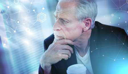 Portrait of thoughtful senior businessman with hand on chin; light effect