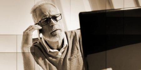 Portrait of bearded senior businessman talking on mobile phone in office, hard light, geometric...