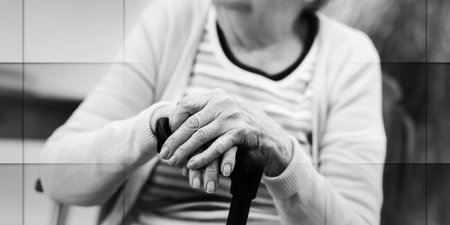 Old woman sitting with her hands on a cane, geometric patternの写真素材