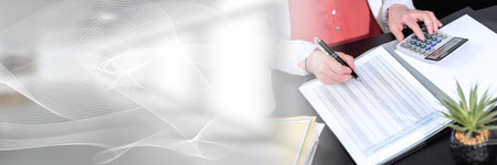 Businesswoman using calculator and working on financial data; panoramic bannerの写真素材