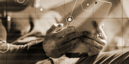 Businessman using his tablet at office, overlayed with network, geometric pattern