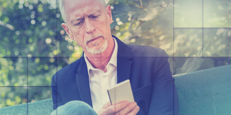 Mature man using his mobile phone outdoors, light effect, geometric pattern