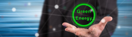Green energy concept above the hand of a man in background