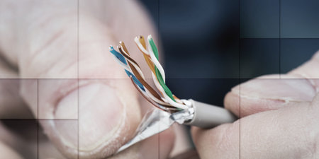 Hand holding an ethernet cable, geometric pattern