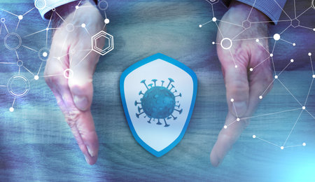 Shield with viruses between hands; concept of prevention and virus protection; light effect