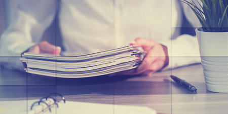 Female hands holding a stack of magazines, geometric pattern