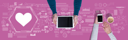 Top view of hands using digital tablet and mobile phone with symbol of online dating concept