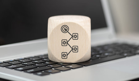 Wooden block with symbol of workflow concept on laptop keyboard