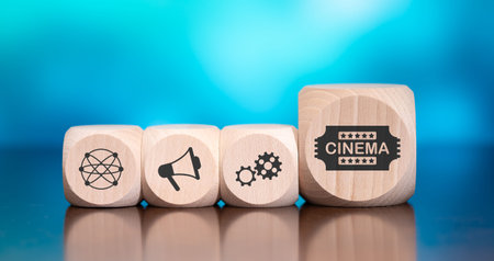 Wooden blocks with symbol of cinema concept on blue background