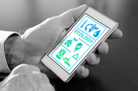 Hand holding a smartphone with ecology conceptの写真素材