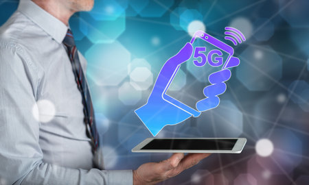 5g concept above a tablet held by a manの写真素材